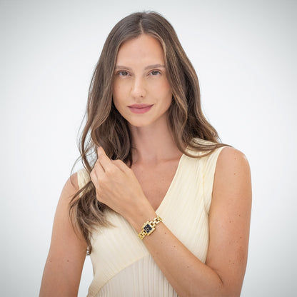 Damenarmbanduhr am Handgelenk mit goldfarbenem Gliederarmband und quadratischem Ziffernblatt