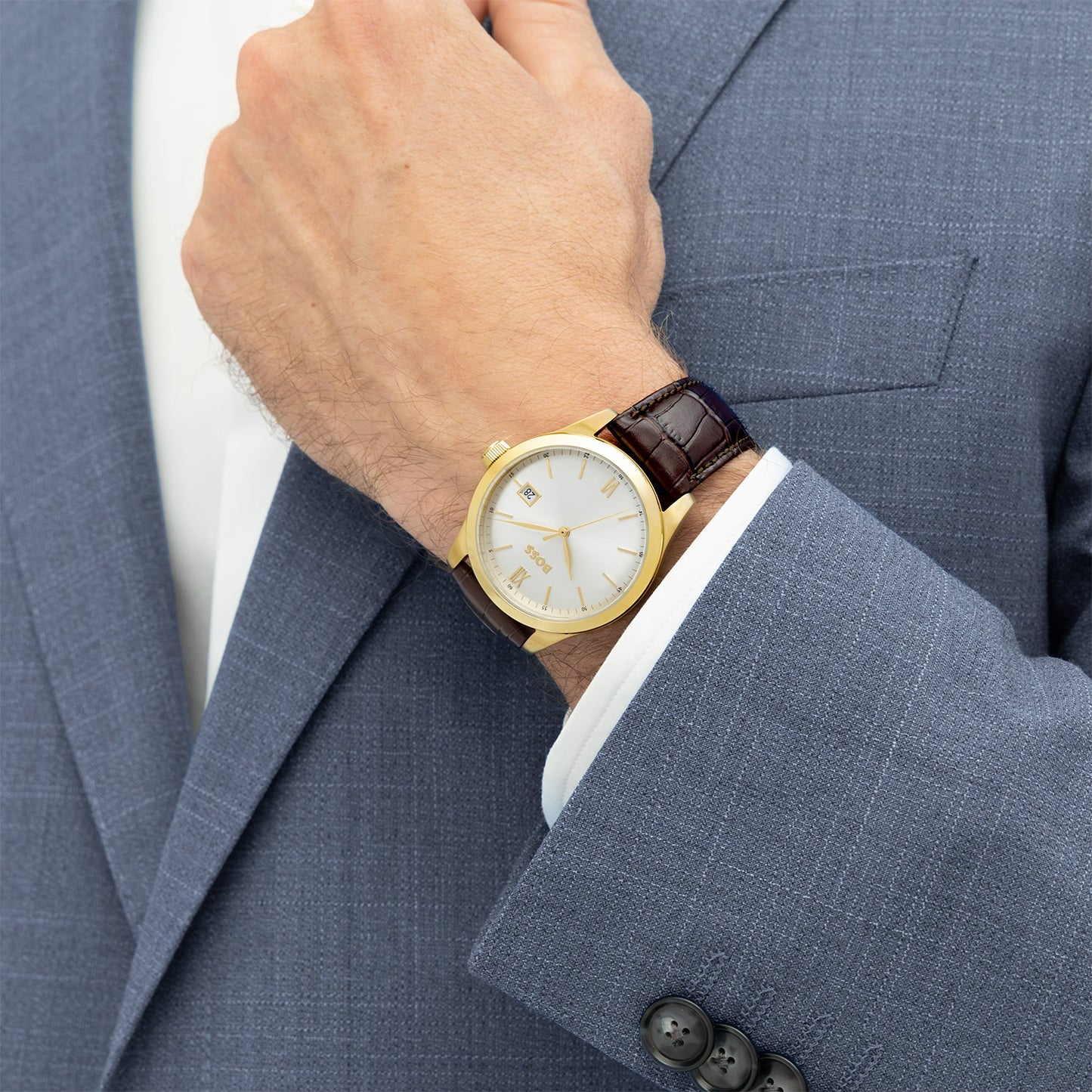 Herrenarmbanduhr am Handgelenk, goldfarbener Gehäuse und braunes Lederband