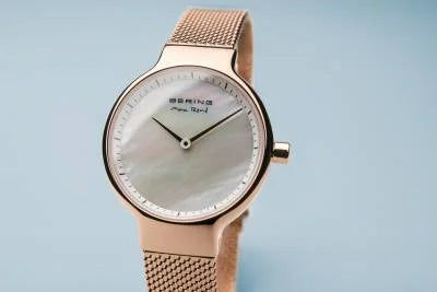 Damenuhr mit Roségoldrand, weißem Zifferblatt und Milanaise-Armband in Nahansicht