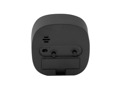 Vue arrière d'un réveil de voyage noir avec compartiment à piles et interrupteur coulissant