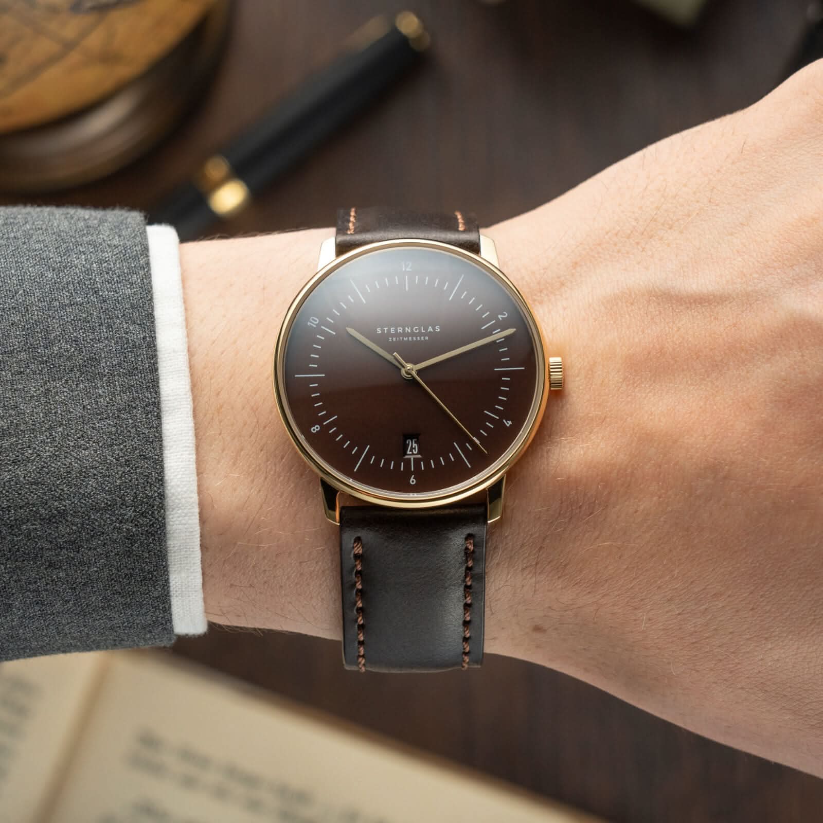 Montre Sternglas pour homme au poignet, bracelet en cuir noir et cadran marron foncé