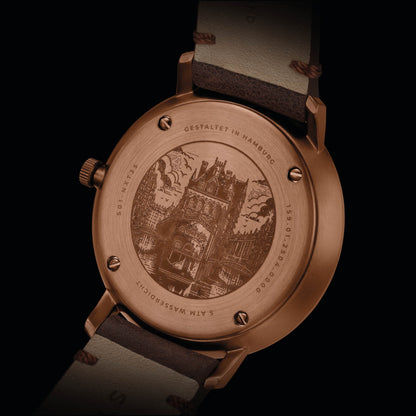 Arrière de la montre pour homme en détail : boîtier couleur bronze avec gravure, bracelet en cuir marron