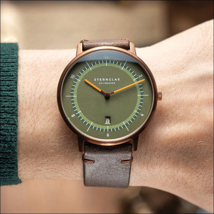 Montre unisexe au poignet : bracelet en cuir marron, cadran vert olive, boîtier en or rose