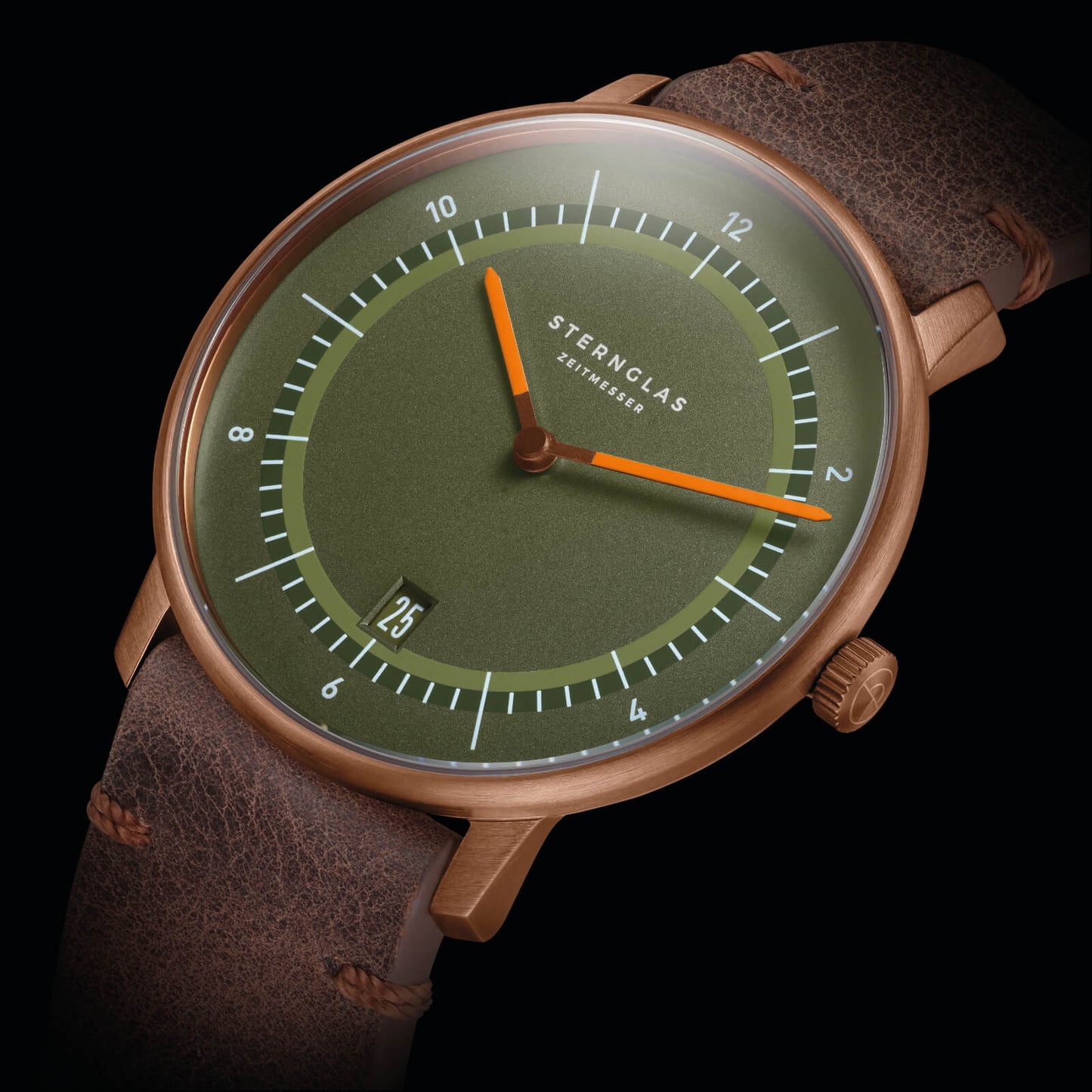 Montre homme gros plan : cadran vert, aiguilles orange, bracelet en cuir marron