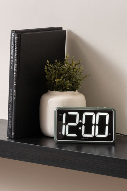 Réveil rétro vert jungle sur une étagère avec chiffres LED 12:00