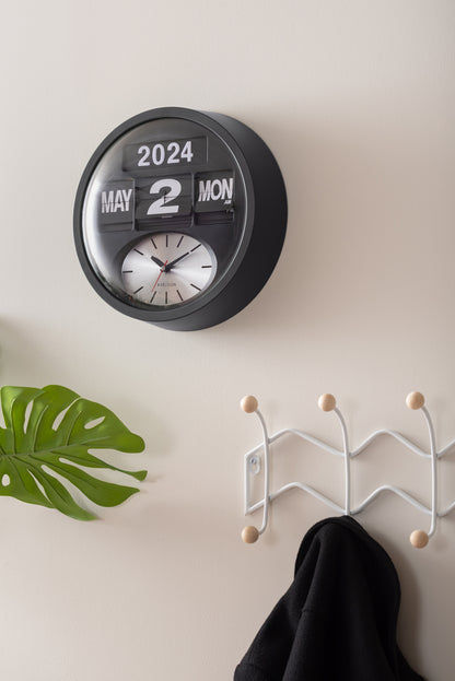 Horloge murale noire sur le mur avec chiffres rabattables et cadran analogique 2024