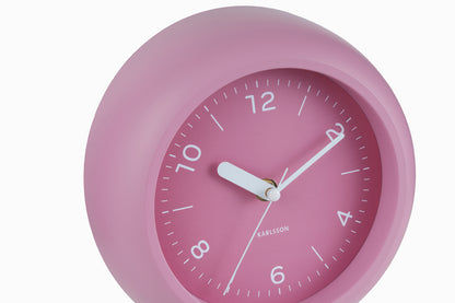 Horloge murale avec cadran rose, aiguilles blanches et indication 12h