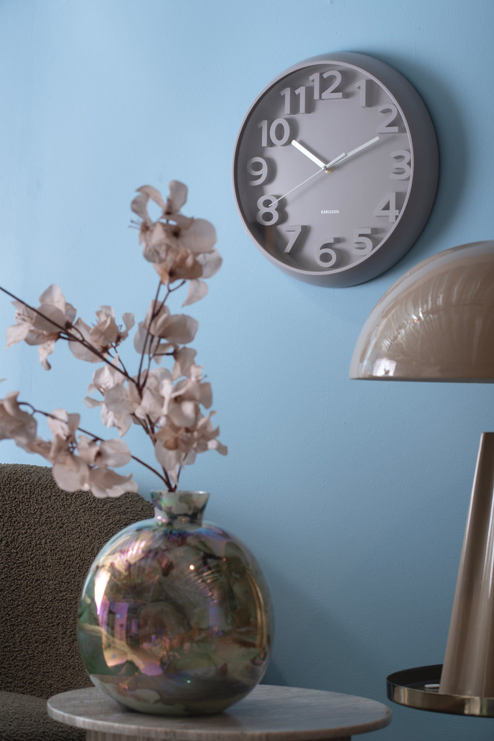 Horloge murale ronde au mur avec chiffres arabes et boîtier gris