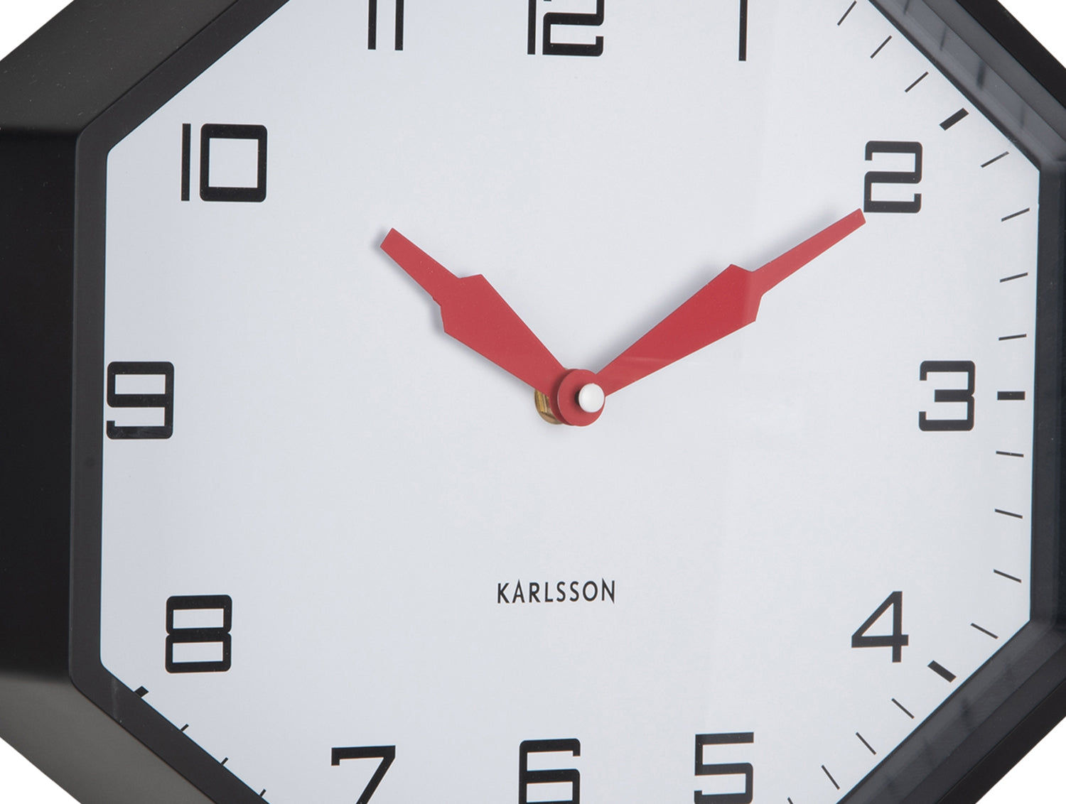Réveil Oktagon, vue détaillée : aiguilles des minutes et des heures rouges sur cadran blanc