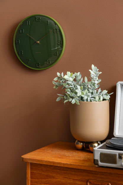 Horloge murale verte avec aiguilles et chiffres dorés sur un boîtier rond