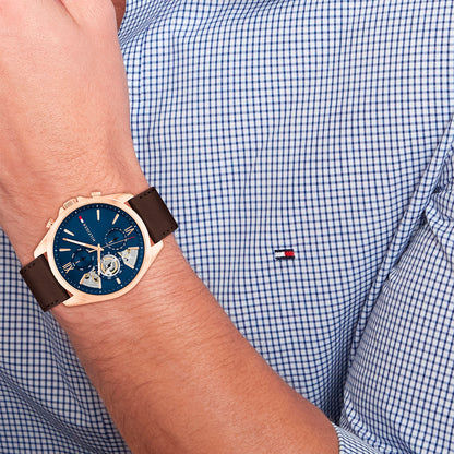 Tommy Hilfiger Armbanduhr am Handgelenk mit blauem Zifferblatt und braunem Lederband