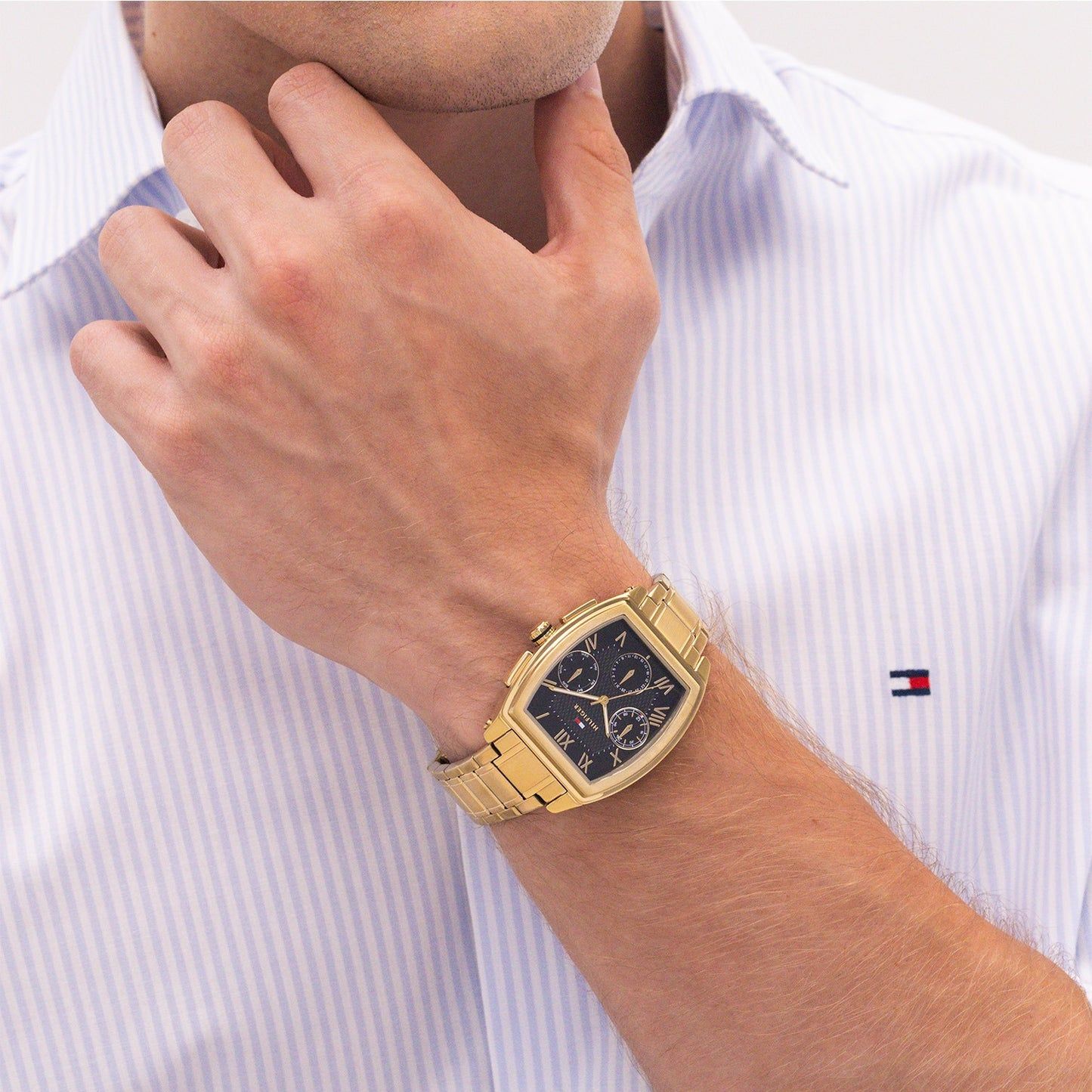 Tommy Hilfiger Uhr am Handgelenk, goldfarbenes Metallband, schwarzes Zifferblatt