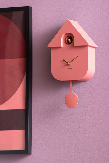 Horloge murale rose en forme de maison avec pendule et fenêtre ronde visible
