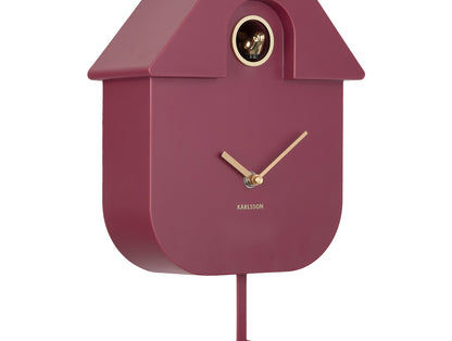 Horloge murale design nichoir, façade rouge foncé avec aiguilles, ouverture en laiton et tige de pendule.