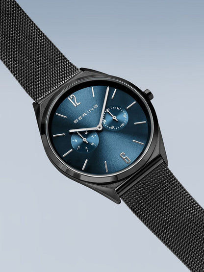 Herren-Uhr mit schwarzem Milanaise-Armband und blauem Zifferblatt, seitliche Ansicht