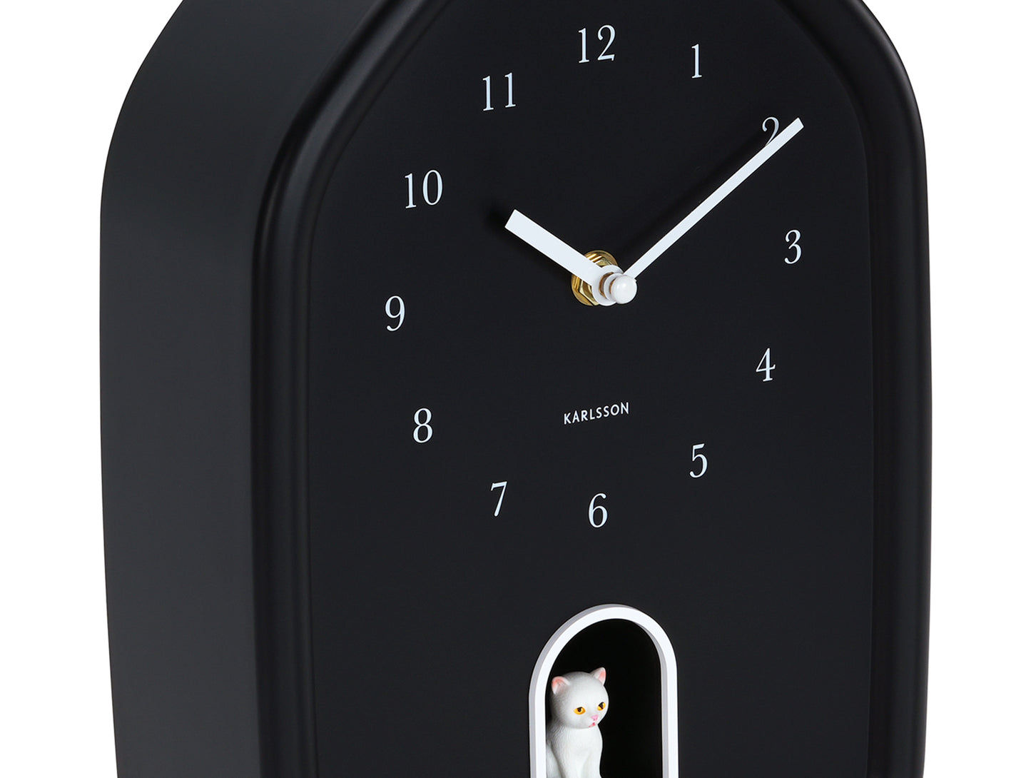 Horloge murale noire en détail avec une figurine de chat en bas et des aiguilles blanches