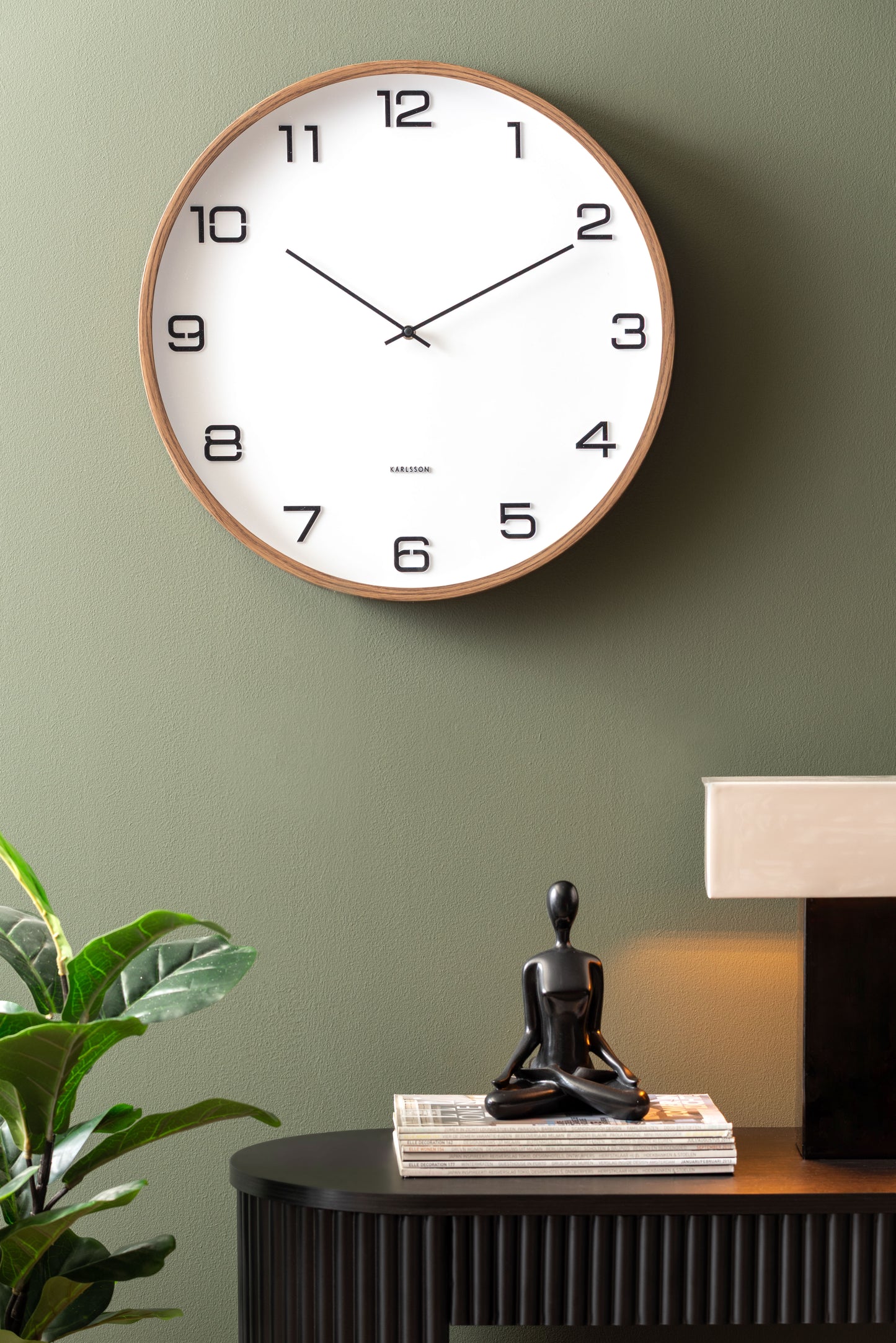 Horloge murale sur un mur avec un cadran blanc et un cadre aspect bois
