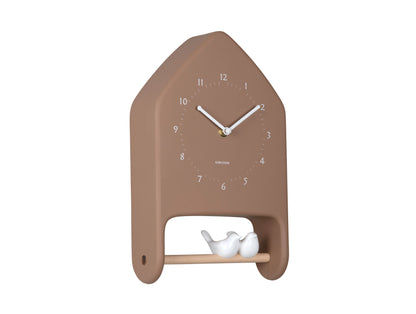 Horloge murale marron avec cadran et deux figurines d'oiseaux blancs dans la fenêtre