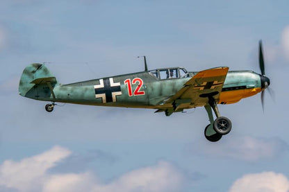 Flugzeug in der Luft mit Markierung „12“ und Tarnanstrich
