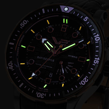 Taucheruhr-Detail mit schwarzem Zifferblatt, Leuchtmarkierungen (grün) und Datumsanzeige.
