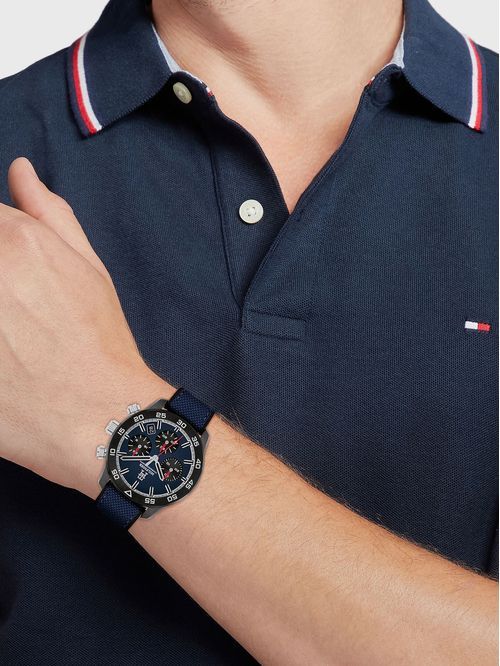 Tommy Hilfiger Armbanduhr am Handgelenk, silberfarbenes Band und schwarzes Chronograph-Zifferblatt