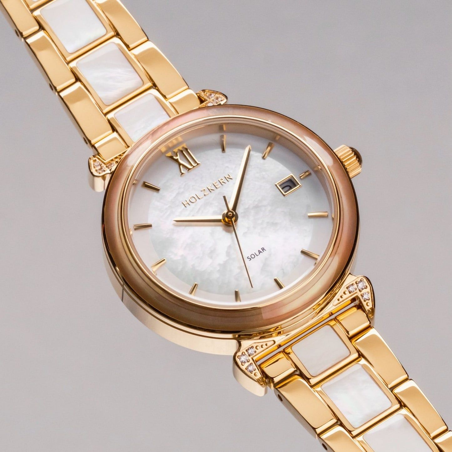 Goldfarbene Damen-Armbanduhr mit weißem Perlmutt-Zifferblatt und römischen Indexen