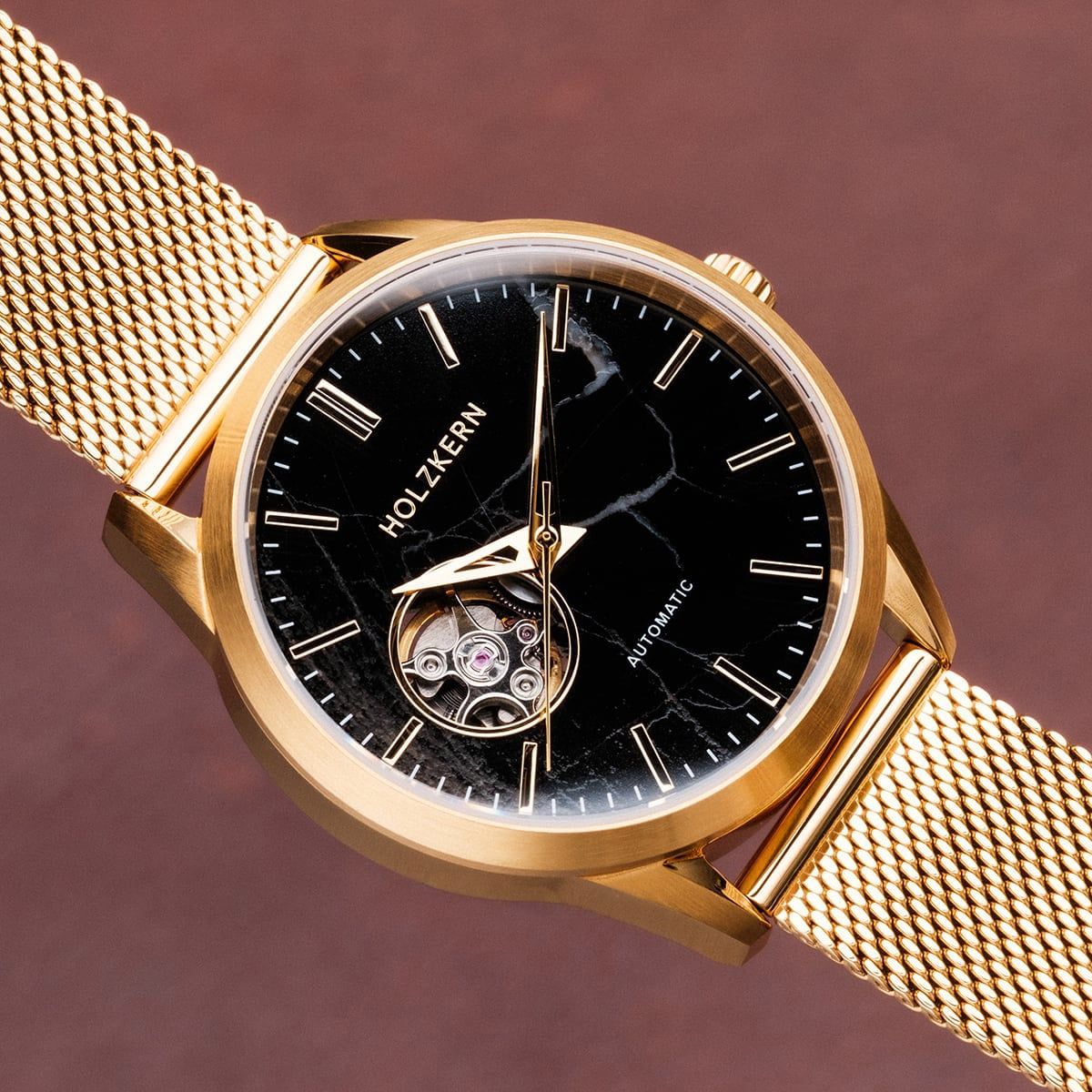 Holzkern Armbanduhr: schwarzes Zifferblatt, goldfarbenes Meshband, Ansicht von der Seite