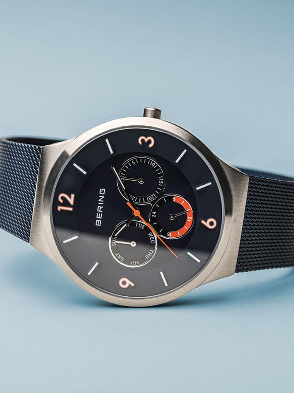 Bering Herrenuhr mit rundem Edelstahlgehäuse, blauem Zifferblatt und blauem Milanaiseband