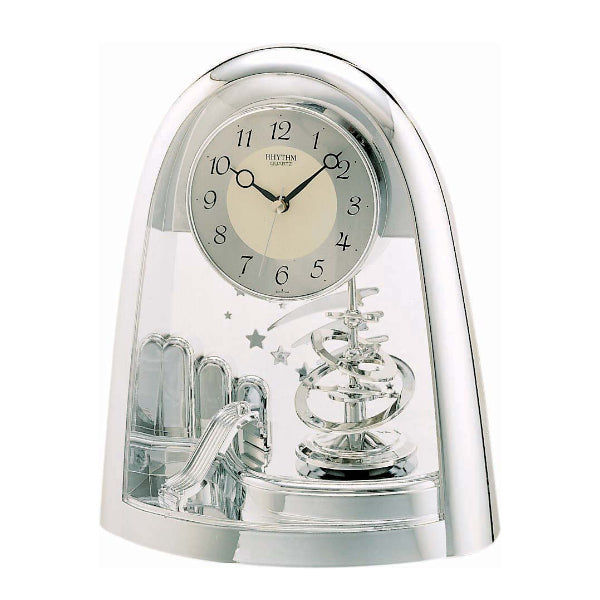 Horloge de table argentée avec cadran rond et pendule visible sous un dôme en verre