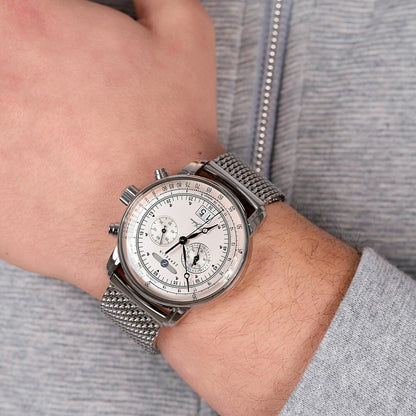 Silberne Herrenarmbanduhr am Handgelenk mit Metall-Mesharmband und weißem Zifferblatt