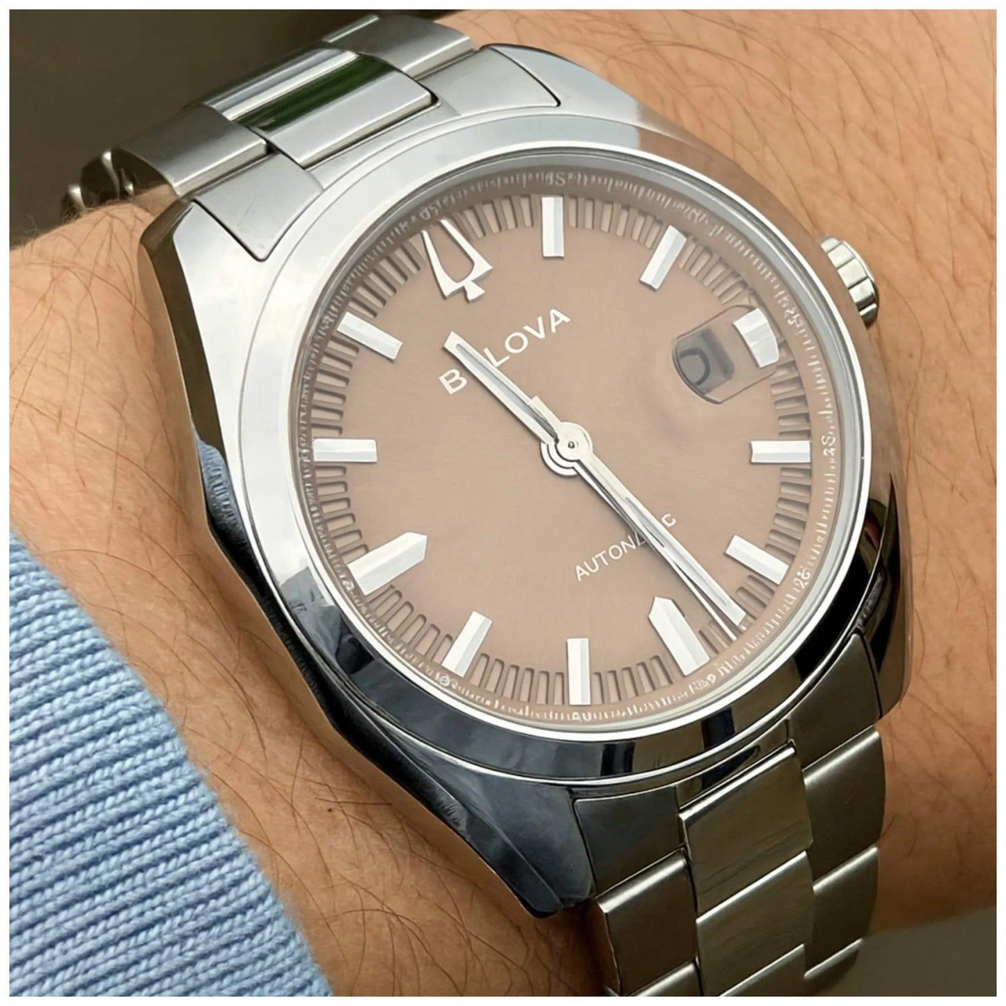 Bulova Herrenuhr am Handgelenk, beiges Zifferblatt und silbernes Edelstahlarmband.