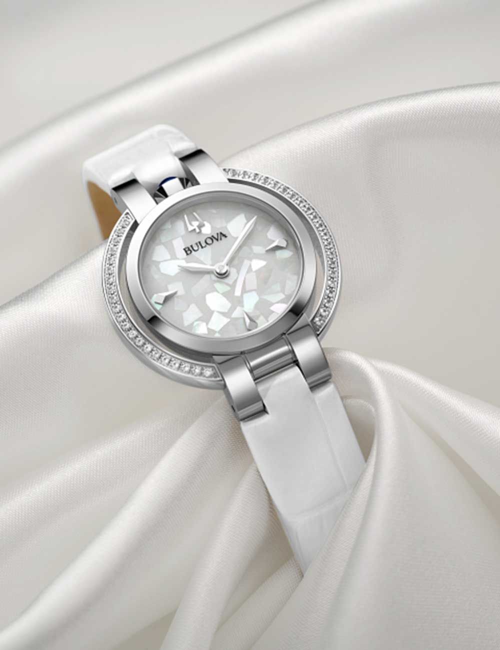 Bulova Damenuhr mit weißem Armband und silberner Lünette mit Ziersteinen, Nahansicht