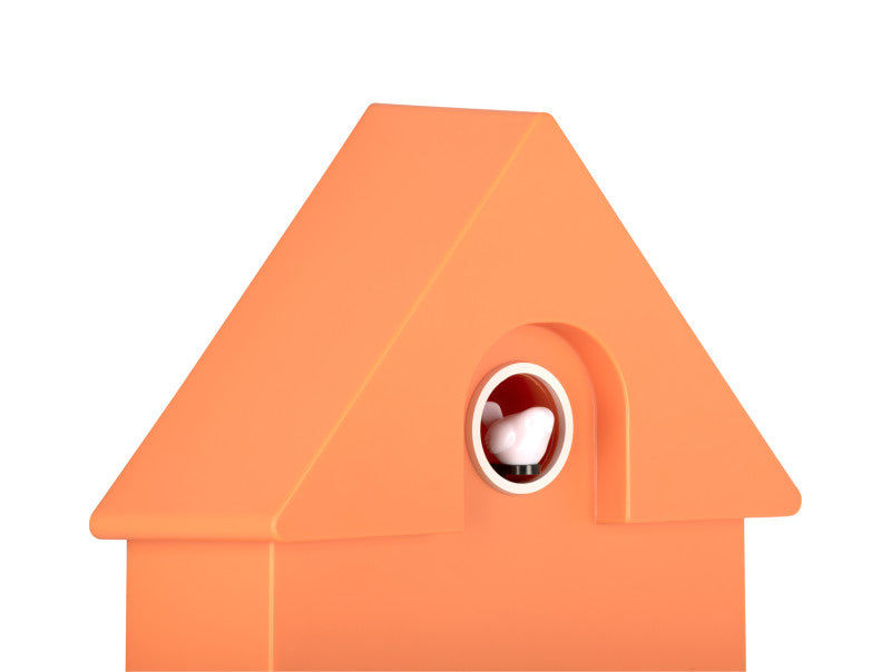Orange väggklocka i husdesign, närbild av det runda fönstret