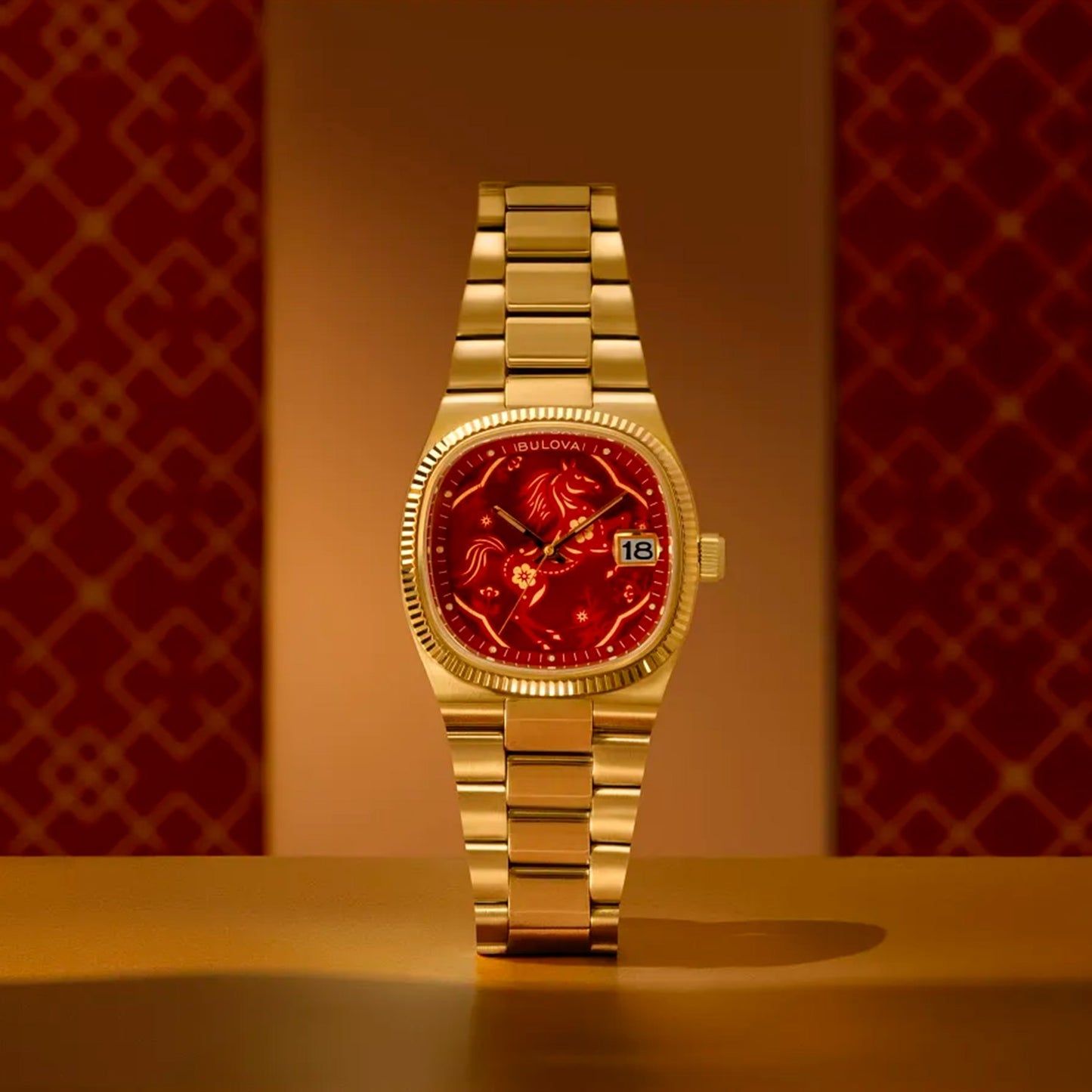 Goldfarbene Herrenarmbanduhr Bulova mit rotem Zifferblatt und Edelstahlband