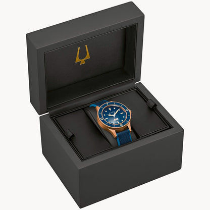 Herrenuhr im geöffneten Etui: blaues Zifferblatt, rosegoldbronzenes Gehäuse und blaues Textilband