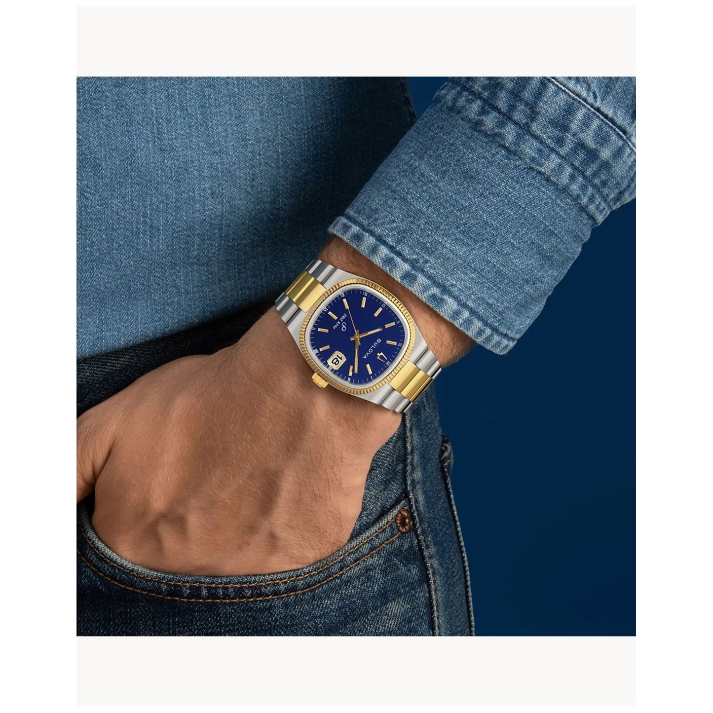 Armbanduhr am Handgelenk mit blauem Zifferblatt und gold-silbernem Edelstahlarmband