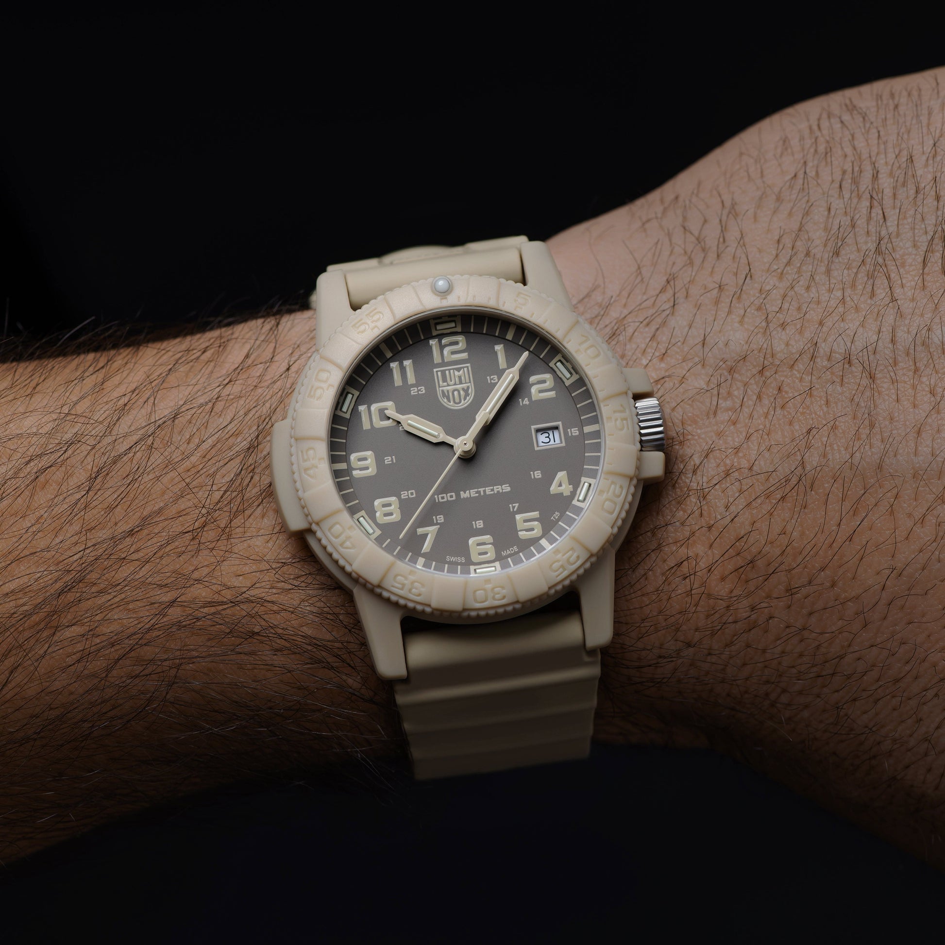 Montre homme au poignet avec bracelet en caoutchouc beige et cadran noir