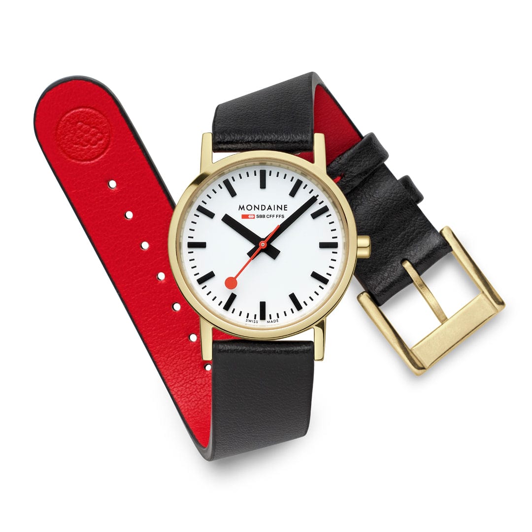 Mondaine-Armbanduhr mit schwarzem Lederarmband und rotem Unterarmband, goldfarbenem Rahmen