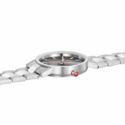 Mondaine-Damenuhr Seitenansicht: Edelstahlgehäuse mit Lünette und integriertem Armband.