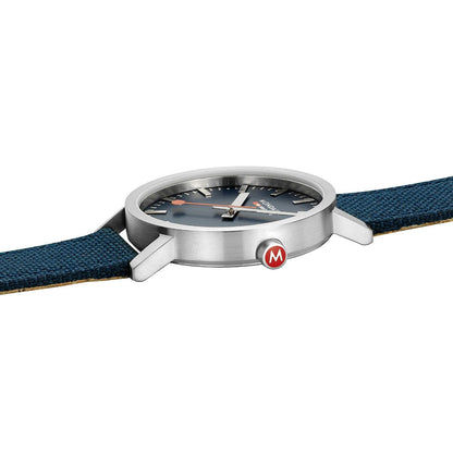 Mondaine Uhr aus Metall mit Sicht auf Krone und blauem Textilarmband