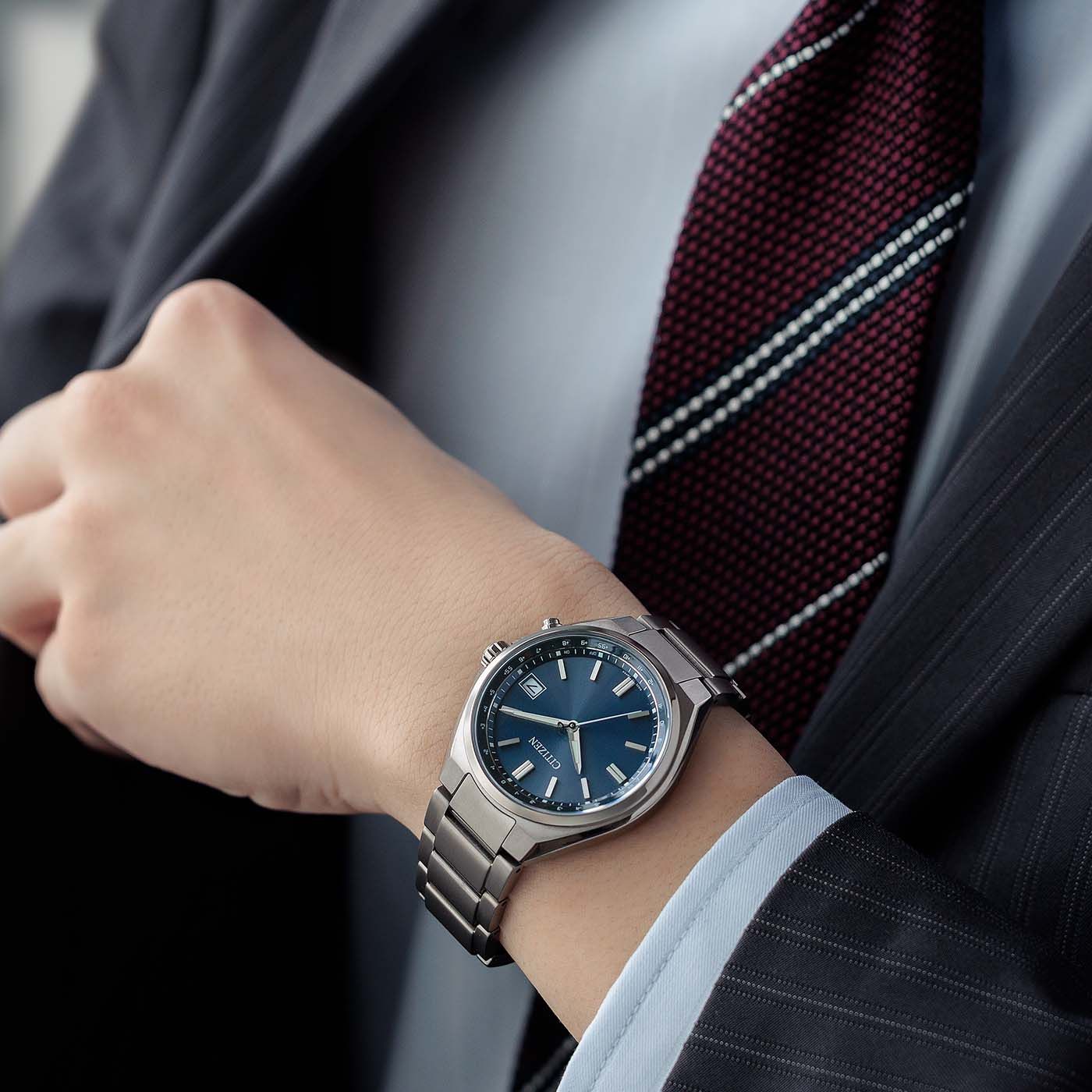 Citizen Armbanduhr am Handgelenk mit blauem Zifferblatt und Metallarmband