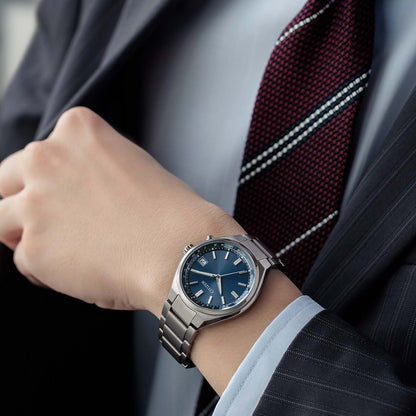 Citizen Armbanduhr am Handgelenk mit blauem Zifferblatt und Metallarmband