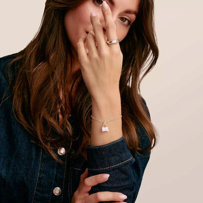 Bracelet avec un petit charm cœur rose au poignet