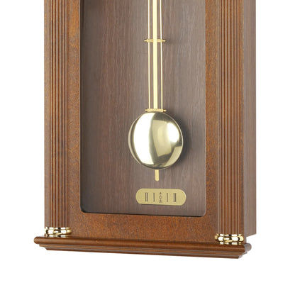 Pendule avec balancier doré et fenêtre rectangulaire en verre dans un boîtier en bois
