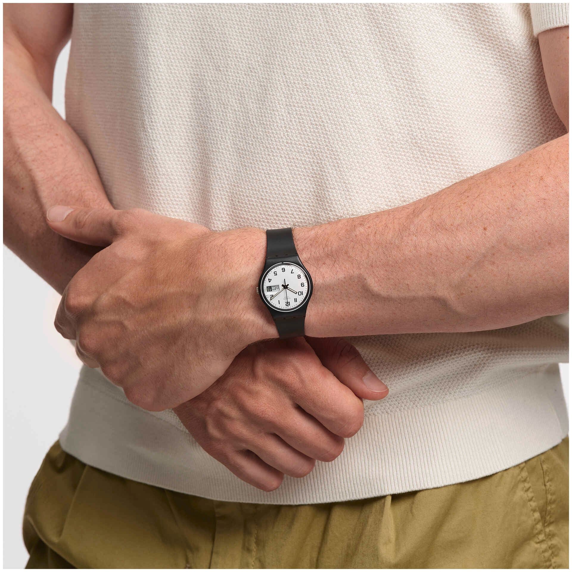 Swatch-Uhr am Handgelenk, schwarzes Silikonarmband mit weißem Zifferblatt und Datum