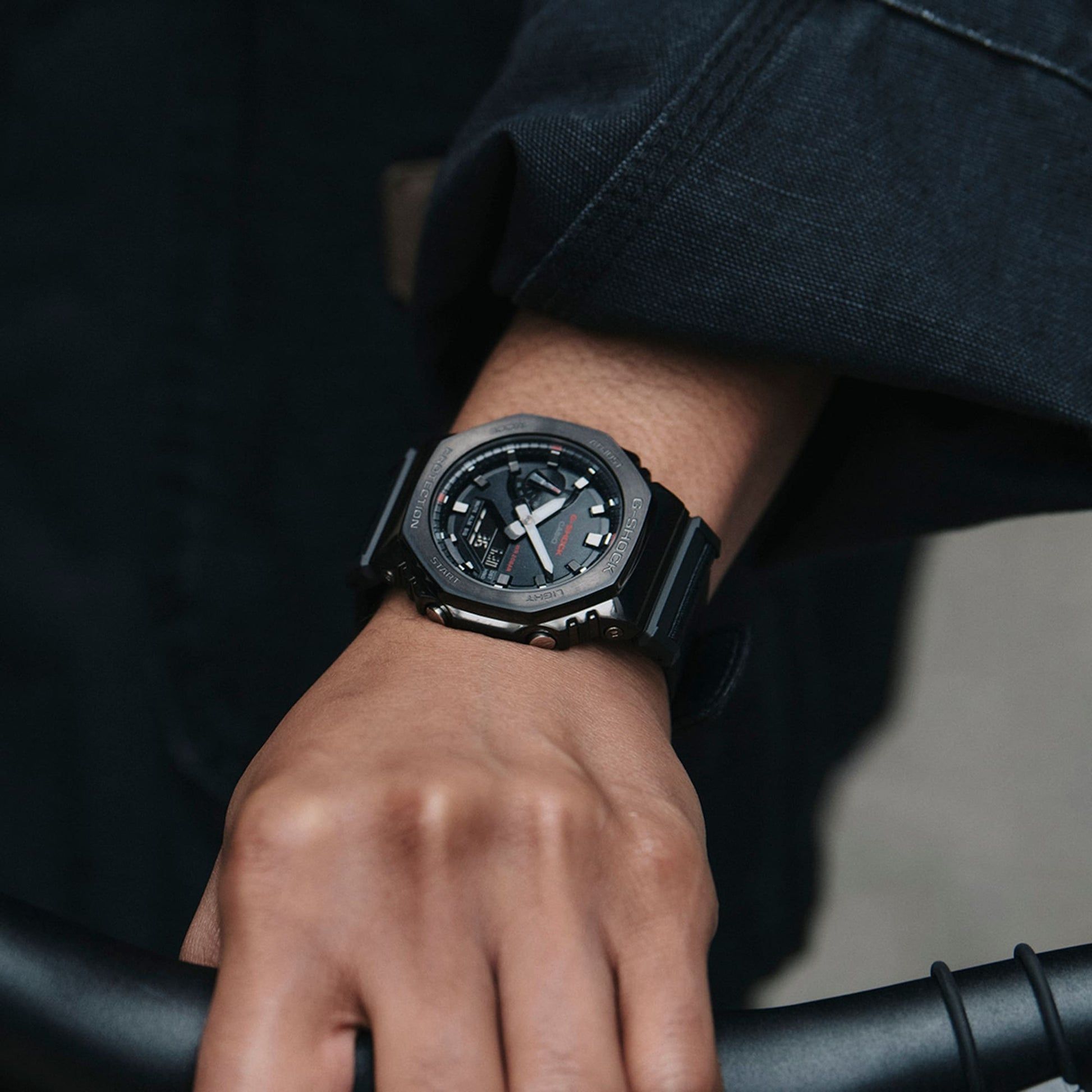 Am Handgelenk getragene G-Shock Herrenuhr mit schwarzem Gehäuse und Stoffarmband