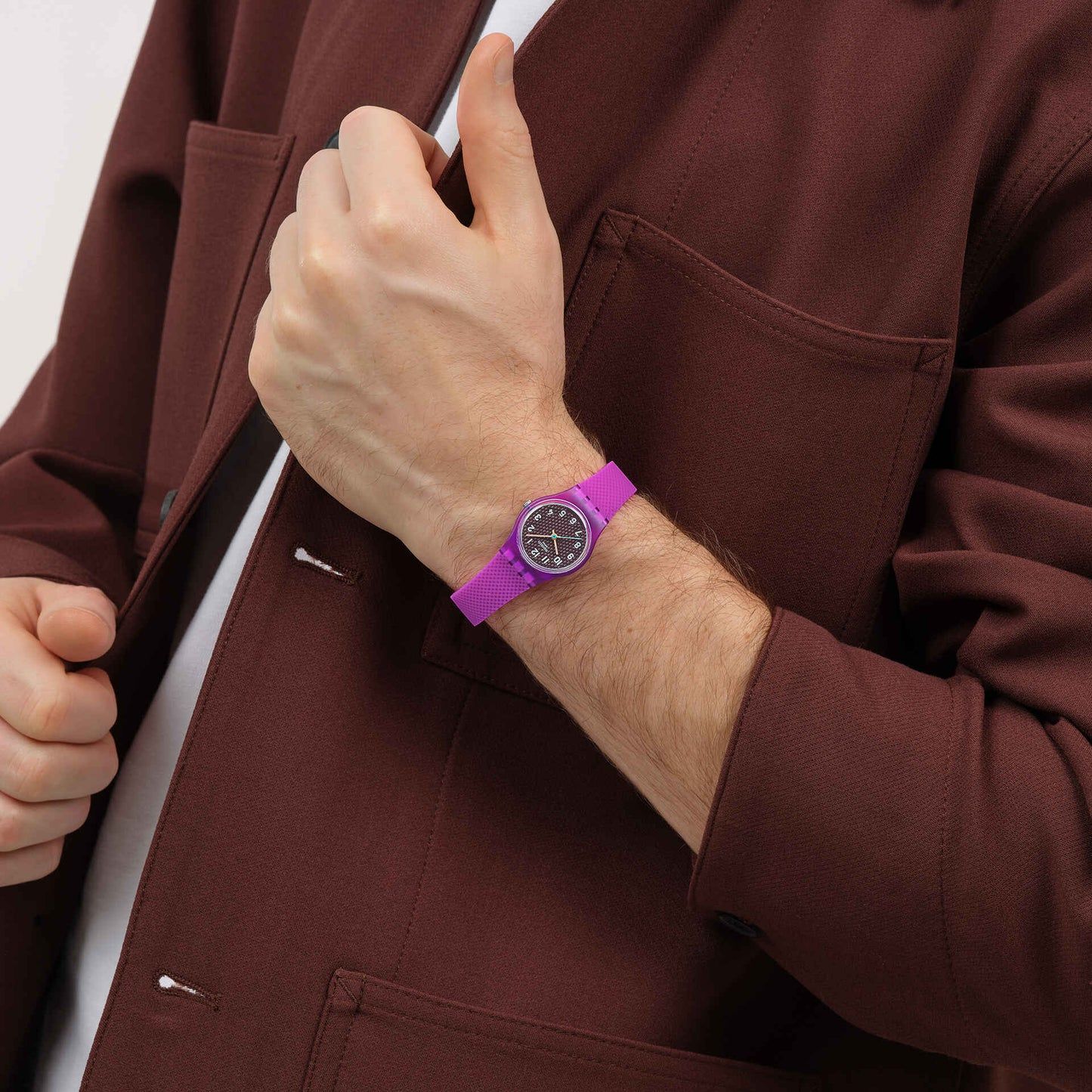 Damenarmbanduhr am Handgelenk mit lila texturiertem Armband und rundem Zifferblatt