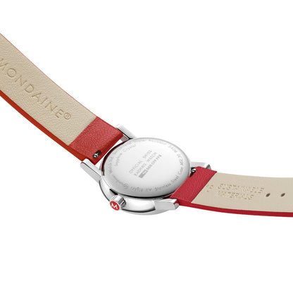Rückseite einer Mondaine Damenuhr mit rotem Armband, Gehäuse in silberfarben