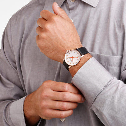 Herrenuhr am Handgelenk mit schwarzem Lederband und weißem Zifferblatt