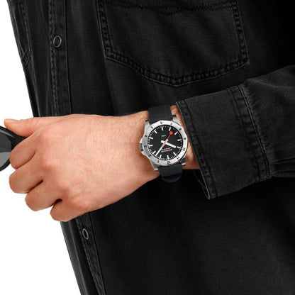 Montre pour homme au poignet : cadran noir et bracelet en silicone noir sur une veste sombre